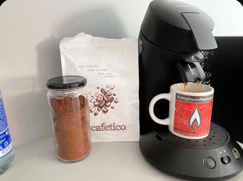 Bolsa de Cafetico junto a una cafetera preparando un café